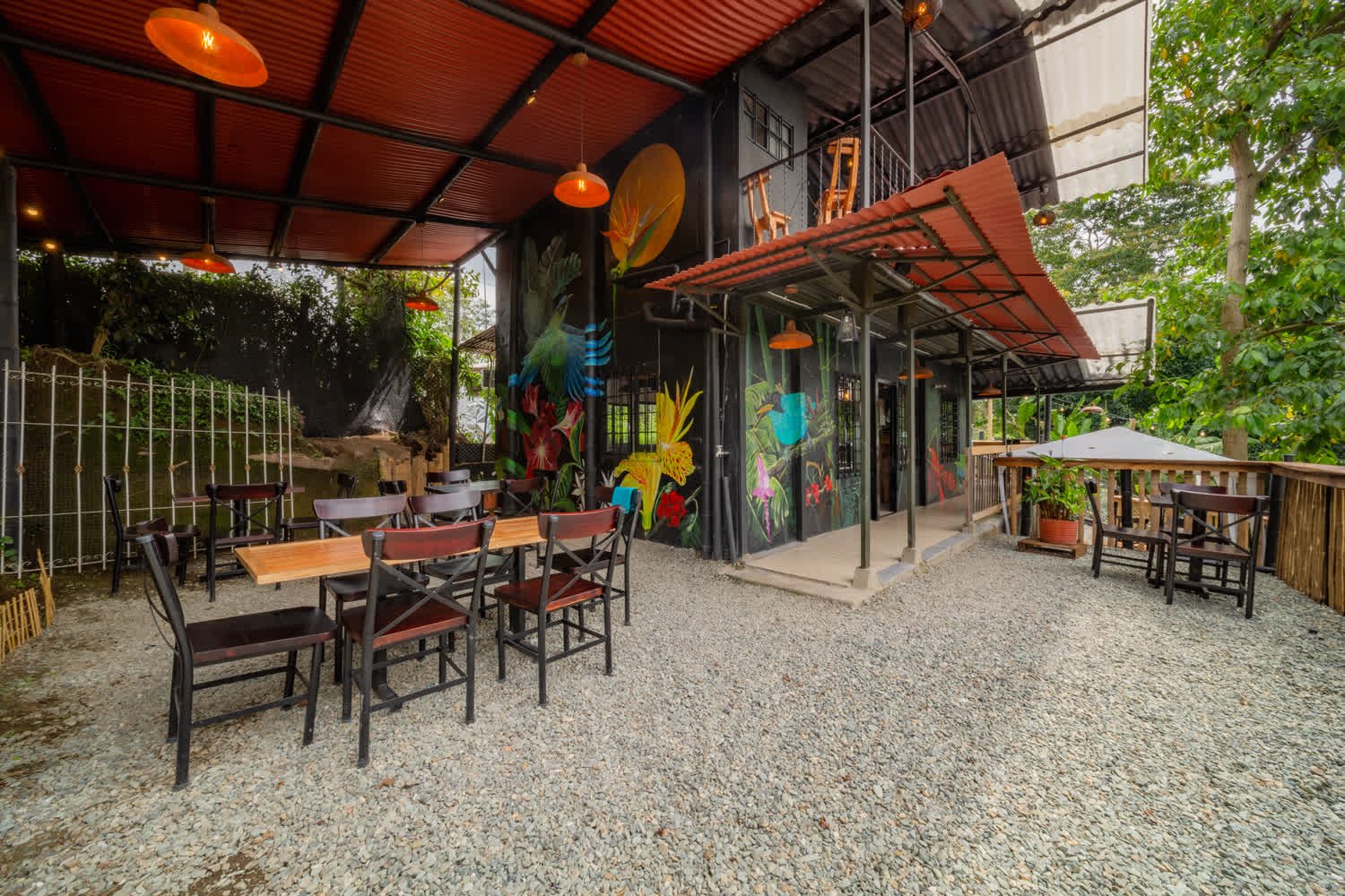 Terraza del café con murales y vista al valle
