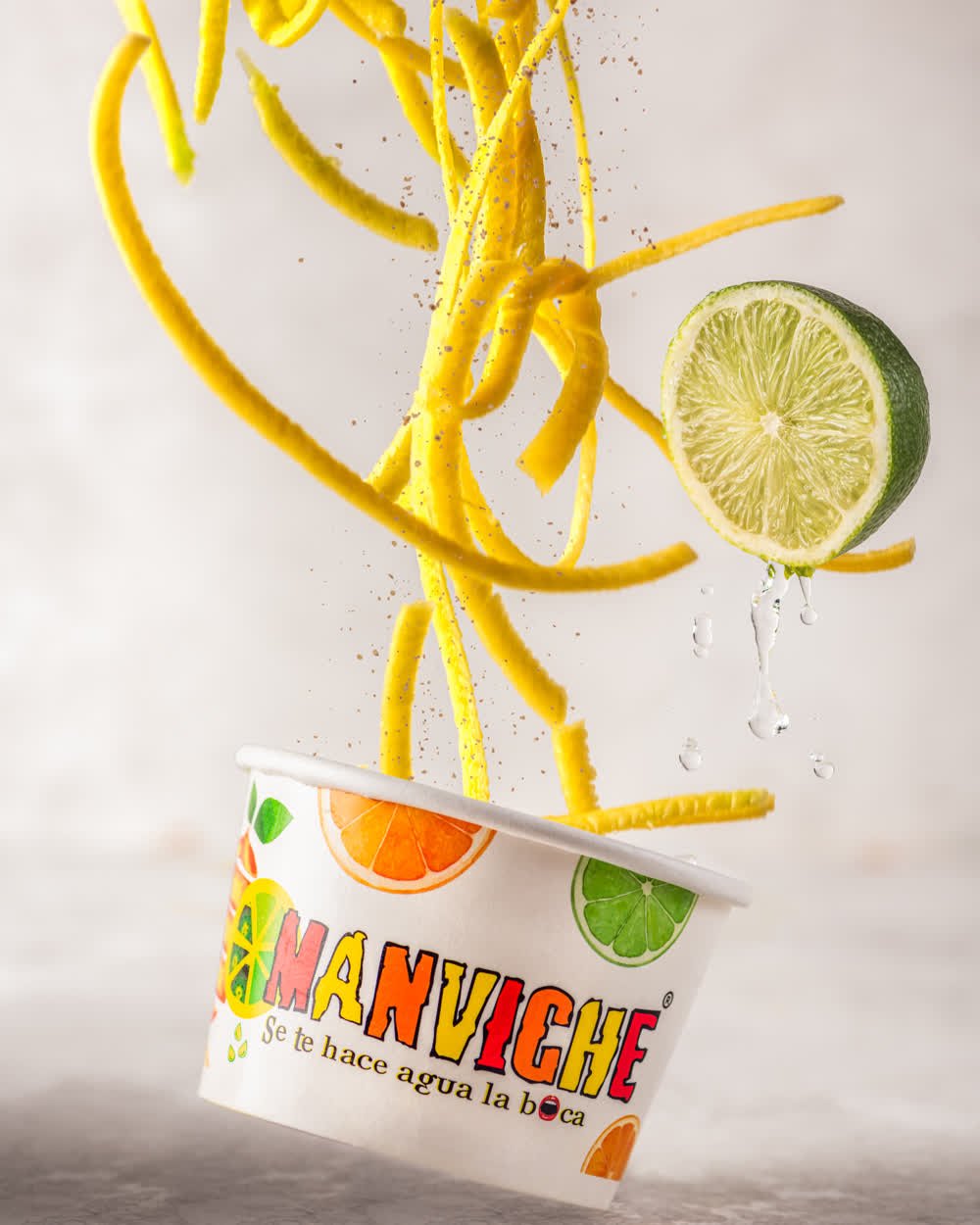 Papas fritas y limón cayendo sobre un vaso de marca, sobre fondo claro