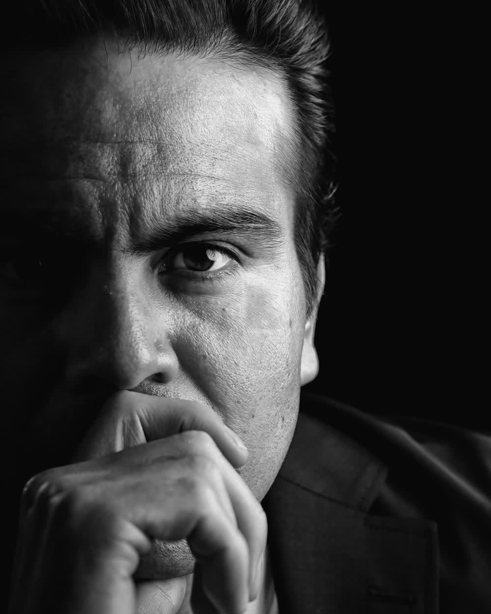 Retrato en blanco y negro de un hombre en traje, mirada directa